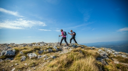 couple-hiking-on-nanos-plateau-in-slovenia-against-blue-sky